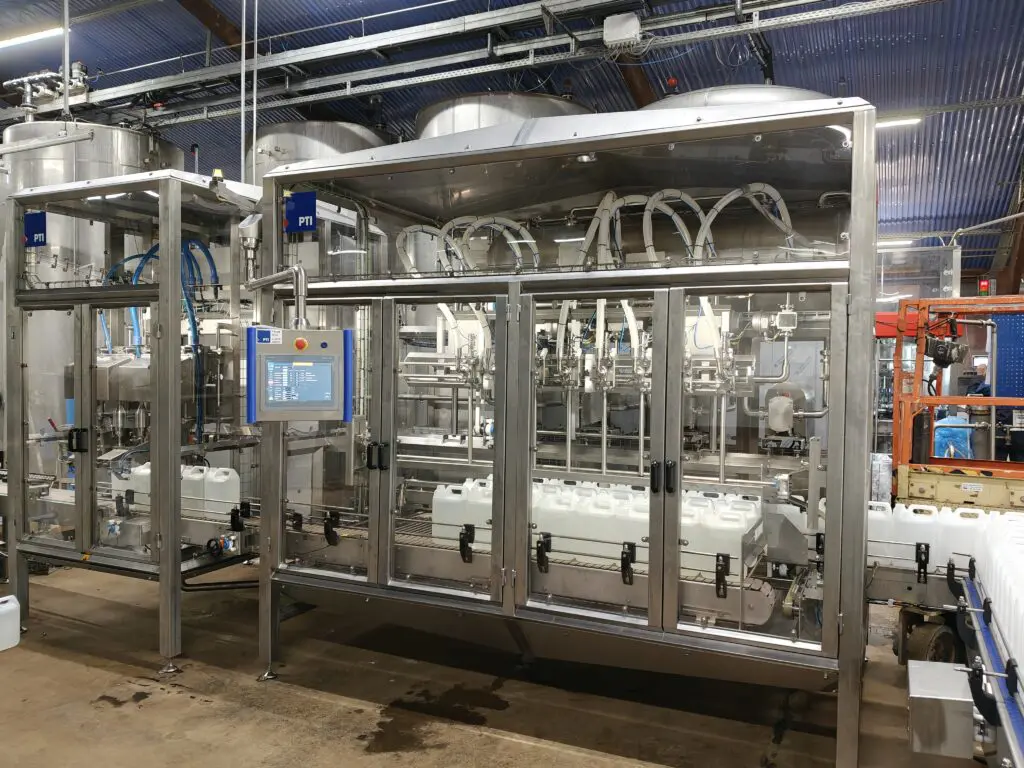 Fuldautomatisk dunkfylder i rustfrit stål til præcis påfyldning af dunke i fødevareindustrien hos PTI A/S.