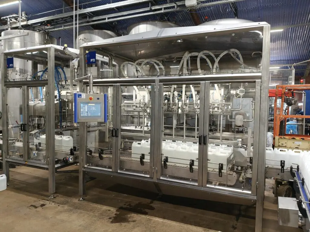 Fuldautomatisk dunkfylder i rustfri stål med transportbånd til præcis påfyldning af flydende produkter.