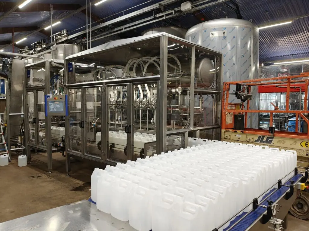 Fuldautomatisk dunkfylder i rustfrit stål til præcis påfyldning af flydende produkter i fødevareindustrien.