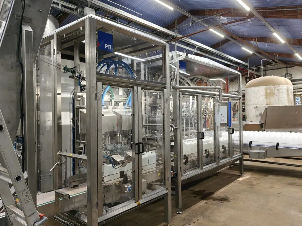 Fuldautomatisk dunkfylder i rustfri stål til præcis påfyldning af flydende produkter i fødevareindustrien.