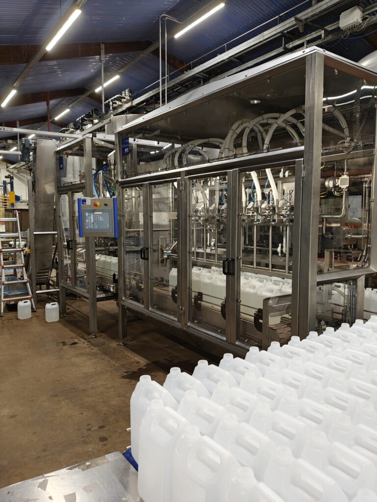 Fuldautomatisk dunkfylder i rustfrit stål til præcis påfyldning af flydende produkter i fødevareindustrien.