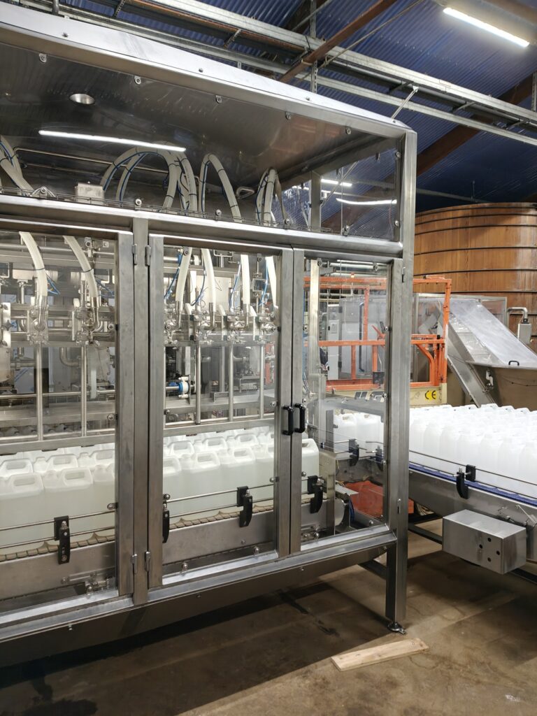Automatisk dunkfylder i rustfri stål til præcis påfyldning af flydende produkter i fødevareindustrien.